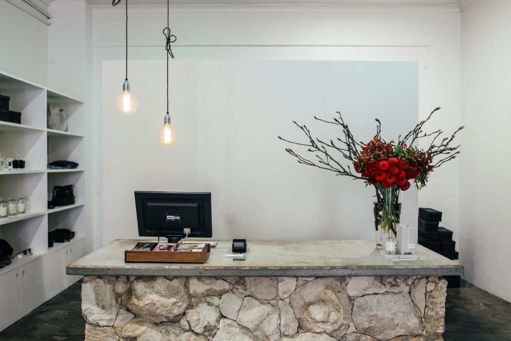 Chic boutique counter with red floral arrangement and stylish decor.